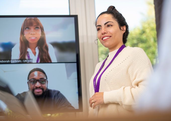 Close up of person in room and on Zoom