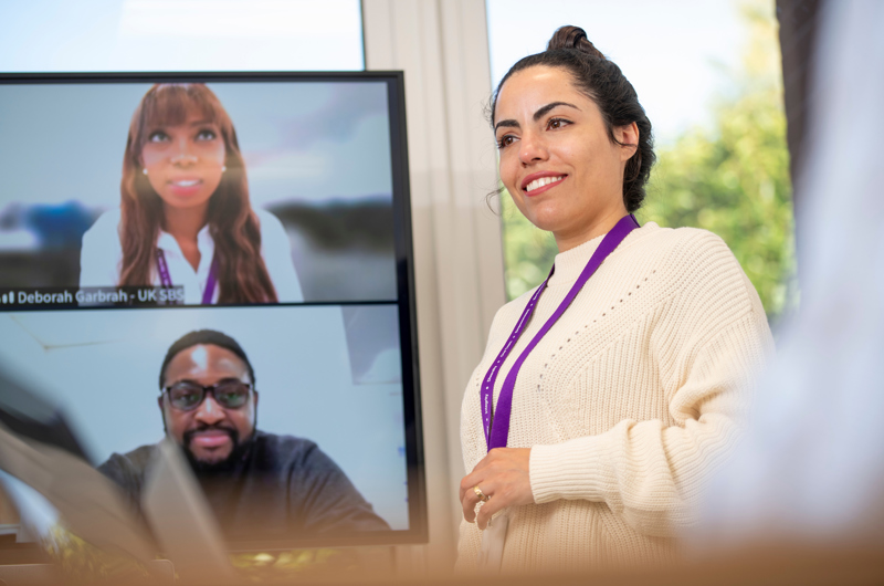 Close up of person in room and on Zoom